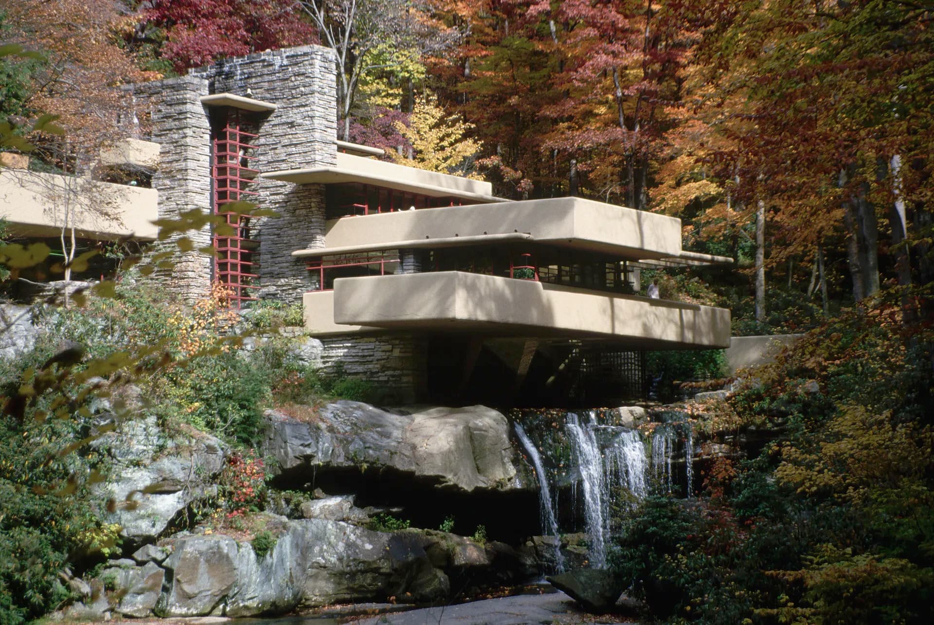 Fallingwater house by Frank Lloyd Wright, surrounded by autumn foliage over a waterfall